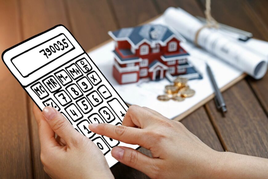 female hand operating calculator front villa house model 1 Доход от продажи недвижимости: как определить прирост стоимости