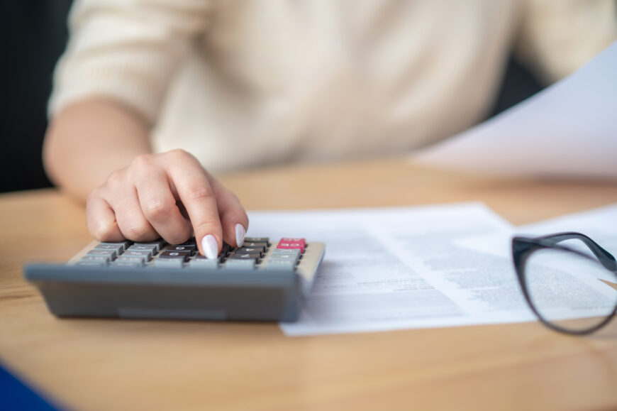bookkeeper calculating financial budget at the office desk 1 Специальный налоговый режим розничного налога: что важно знать?